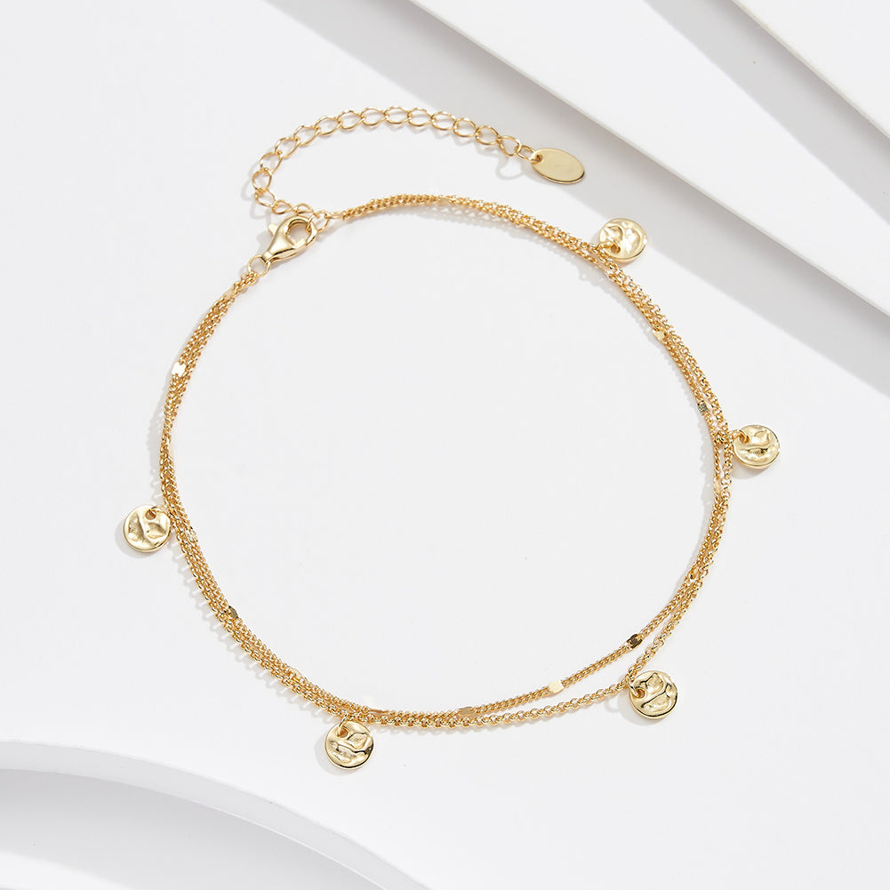Gold anklet featuring small round pendants