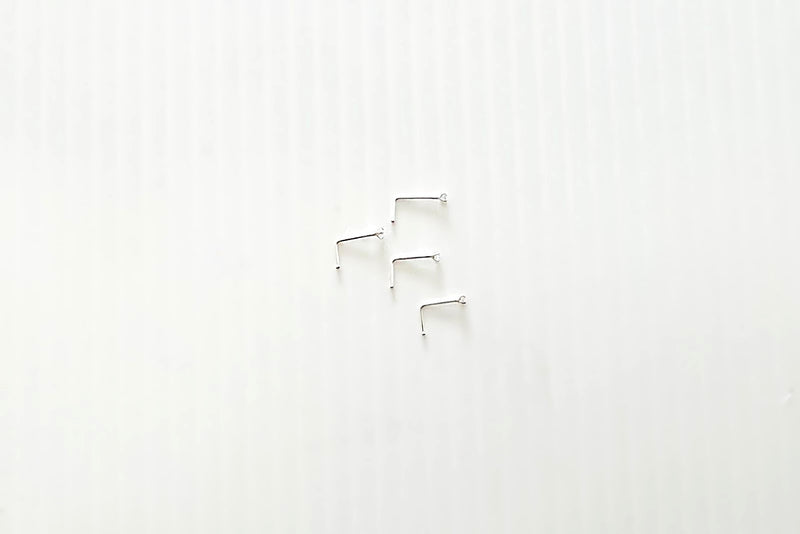 A close-up image of a sterling silver nose stud with an L-shaped hook, showing the texture of the silver and the slight sheen.