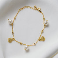 A sterling silver gold vermeil bracelet with freshwater pearl and shell-shaped silver elements