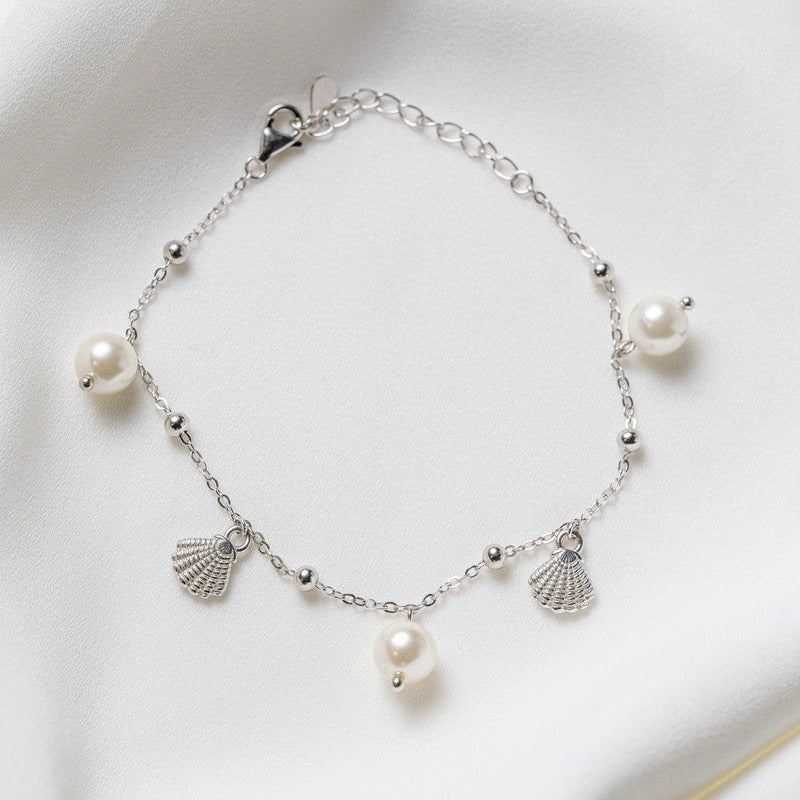 A sterling silver bracelet with freshwater pearl and shell-shaped silver elements