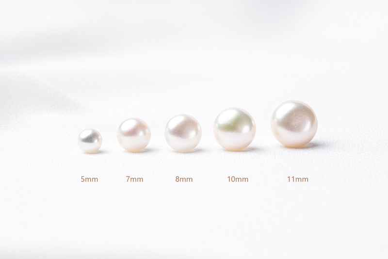 A series of pearls in various sizes displayed in a line, with labels indicating their sizes: 5mm, 7mm, 8mm, 10mm, and 11mm. On a white background