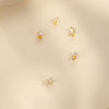 Set of gold earrings on a beige background