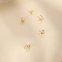 Set of gold earrings on a beige background