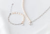 Pearl bracelet and matching necklace with a silver heart charm on a white background
