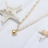 Pearl necklace gold vermeil with a gold heart pendant on a white background 