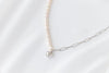 Pearl necklace silver with a gold heart pendant on a white background 