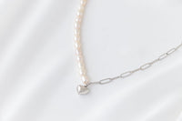 Pearl necklace silver with a gold heart pendant on a white background 
