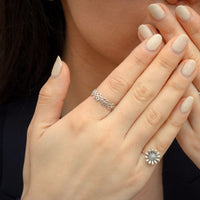 Close-up of hands wearing sterling silver floral daisy ring