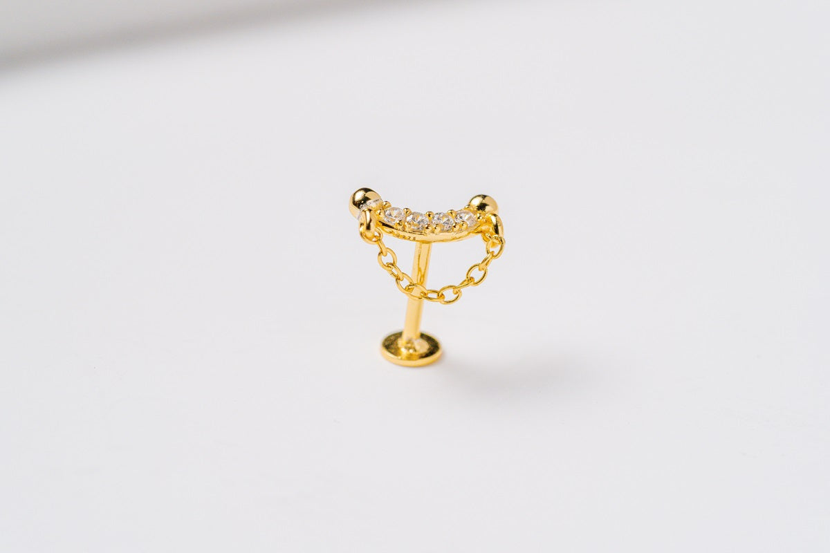 A gold stud earring featuring cubic zirconias and a fine chain design to look like a shield on a white background