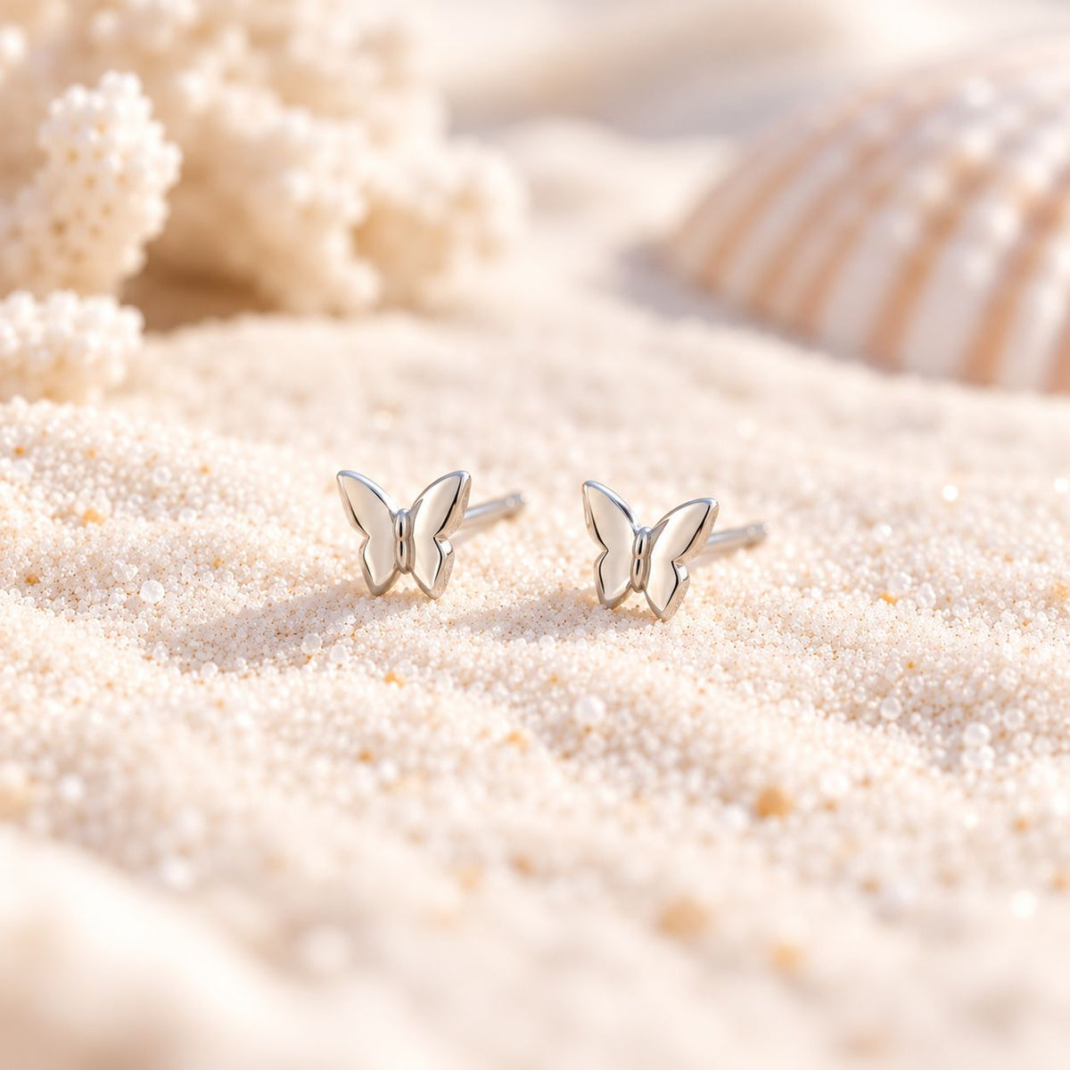sterling silver butterfly stud earrings on sand