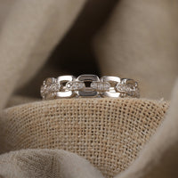 Sterling Silver ring with diamond CZ accents on a textured beige surface