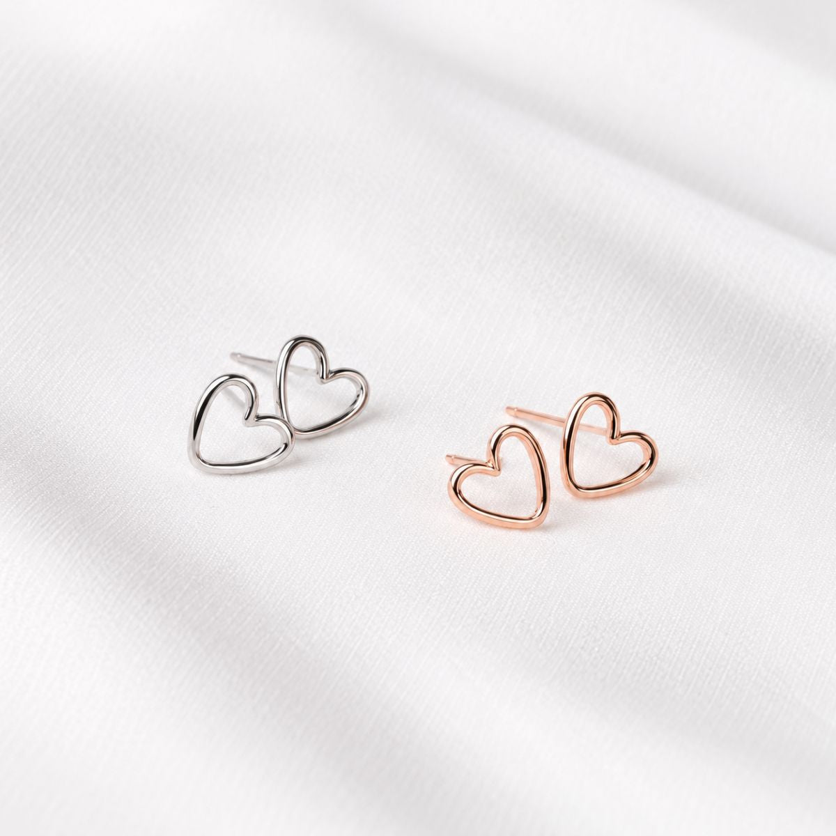 silver and rose gold love heart shaped studs in sterling silver