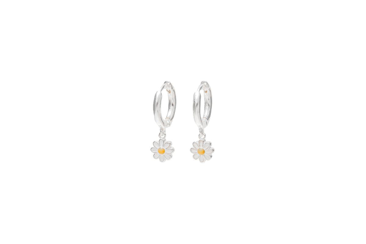 A pair of sterling silver huggie earrings with a single daisy design on a white background.