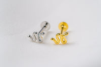 A silver and a gold shaped earring on a white background