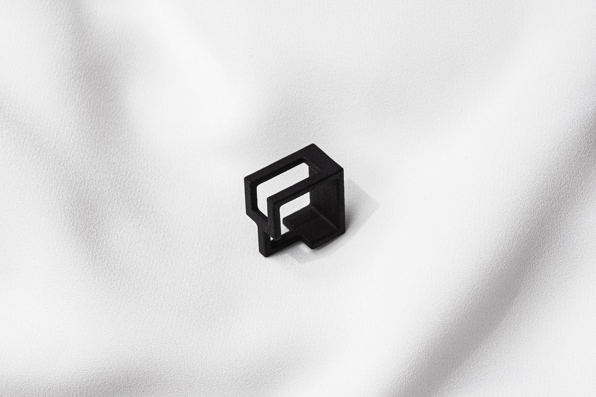 A matte black ring with a minimalist design, 3D printed from sustainable PA12 nylon, displayed on a white background.