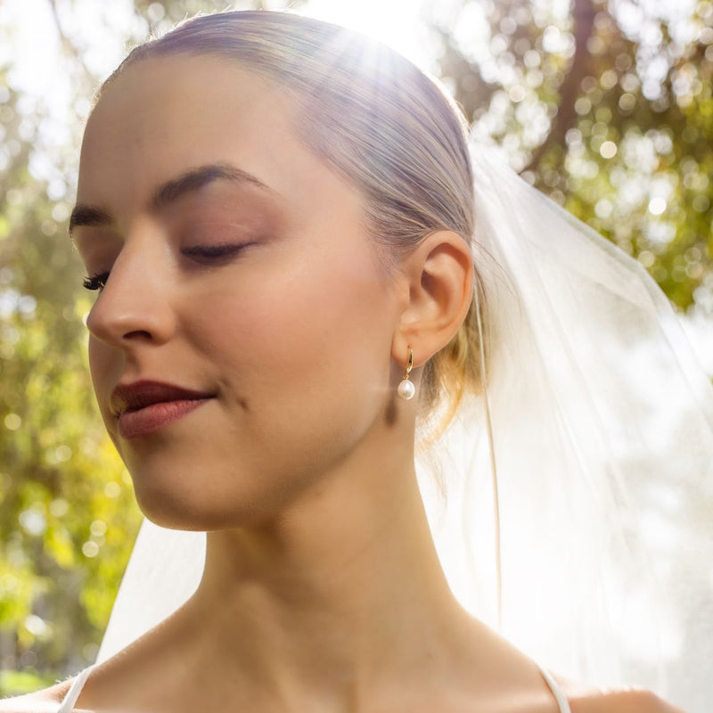 Woman wearing a wedding veil with a blurred natural background