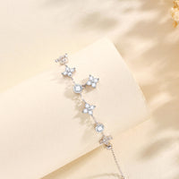 A silver bracelet with star-shaped charms, displayed against a neutral background.
