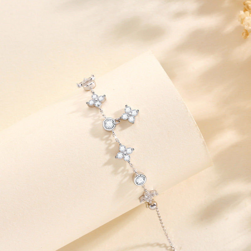 A silver bracelet with star-shaped charms, displayed against a neutral background.