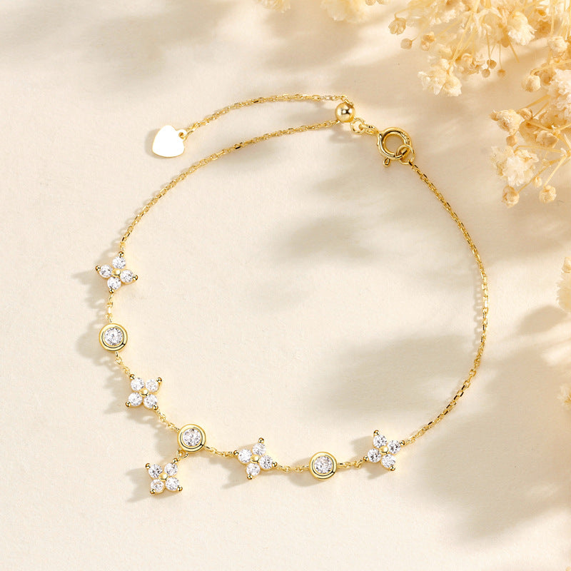 A silver bracelet with star-shaped charms, displayed against a neutral background.