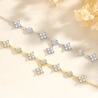 A gold and a silver bracelet featuring cubic zirconias on a floral background