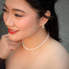 Woman wearing a rice shape freshwater pearl necklace and earrings 
