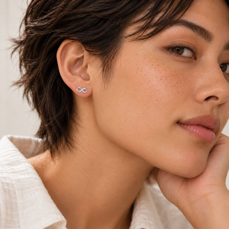 silver infinity stud with cubic zircon worn by a model