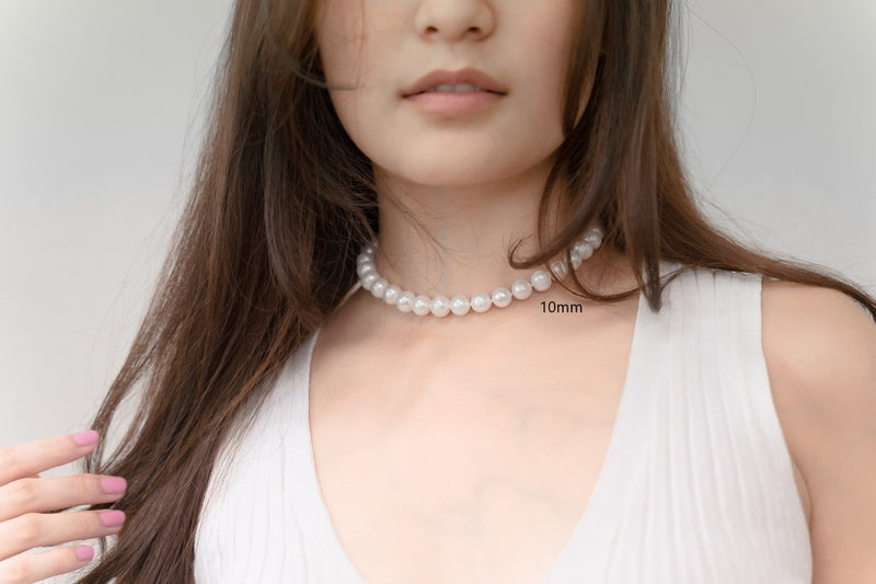 A woman wearing a white dress and a choker 10 mm pearl necklace 
