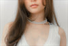 A woman wearing a white dress and a choker 6 mm and 8 mm pearl necklace 