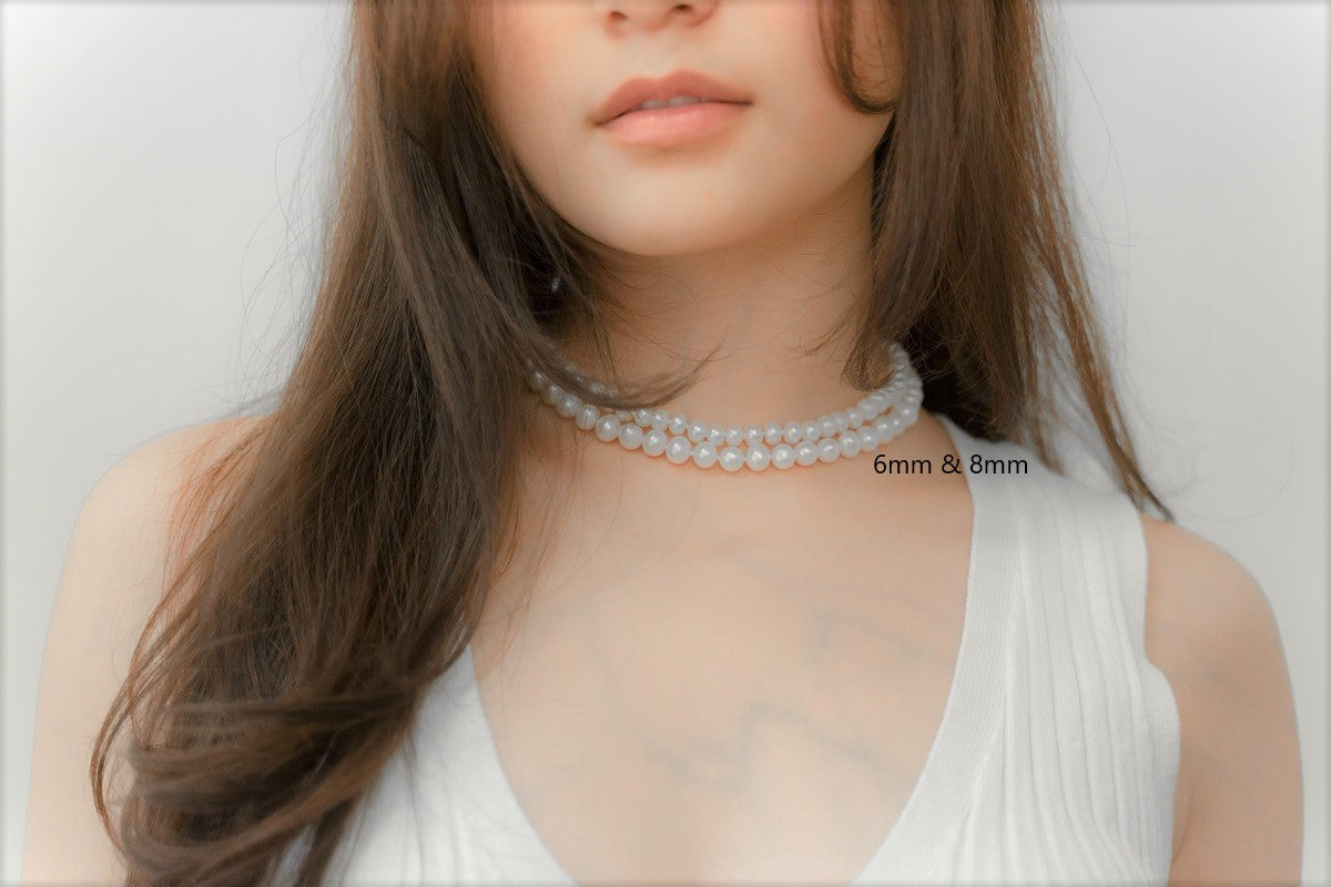 A woman wearing a white dress and a choker 6 mm and 8 mm pearl necklace 