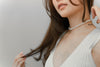 A woman wearing a white dress and a choker 6 mm pearl necklace 