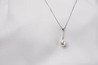 A classic drop pearl necklace with a silver chain and a white pearl pendant, displayed on a neutral background.