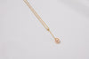 A classic drop pearl necklace with a gold chain and a champagne pearl pendant, displayed on a neutral background.