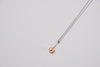 A classic drop pearl necklace with a silver chain and a champagne pearl pendant, displayed on a neutral background.