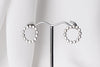 A pair of silver stud earrings, displayed on a metal earring stand against a white background