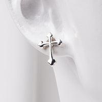 an earlobe model wearing sterling silver cross stud