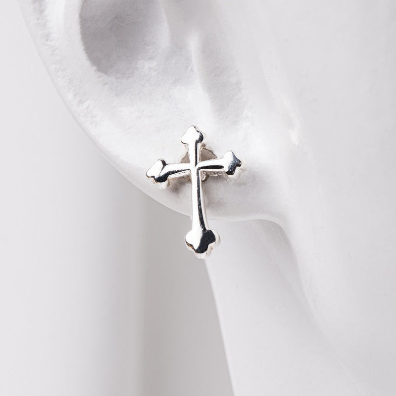 an earlobe model wearing sterling silver cross stud