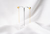 A pair of dangle earrings with a drop tail, butterfly backs, and a silver-colored post on a white stand against a white backdrop.