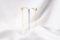 A pair of dangle earrings with a drop tail, butterfly backs, and a silver-colored post on a white stand against a white backdrop.