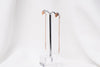 A pair of dangle earrings with a drop tail, butterfly backs, and a silver-colored post on a white stand against a white backdrop.