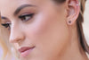 A pair of dangle earrings with a drop tail, butterfly backs, shown on a model.