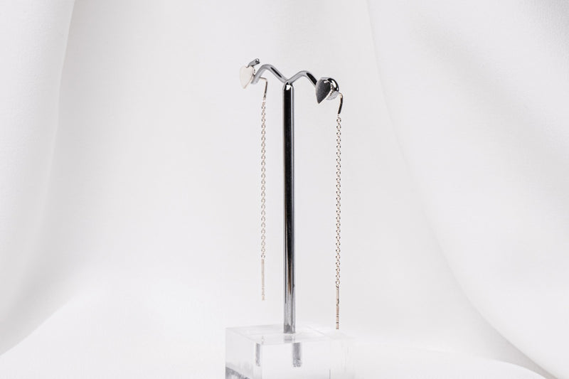 A pair of dangle earrings with a drop tail, butterfly backs, and a silver-colored post on a white stand against a white backdrop.