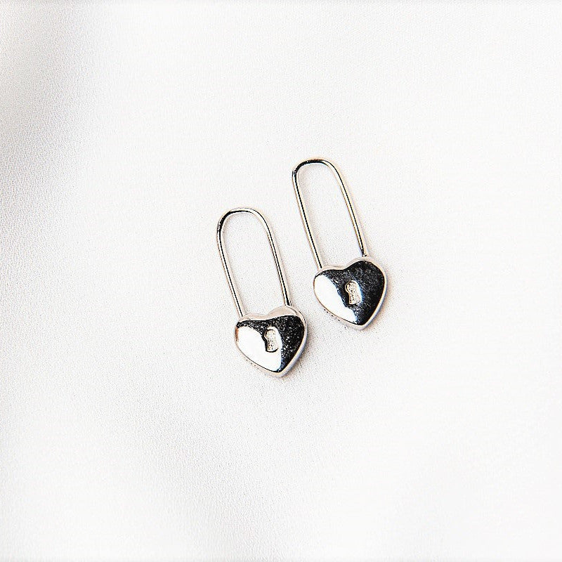 A pair of silver heart lock shaped earrings on a white background