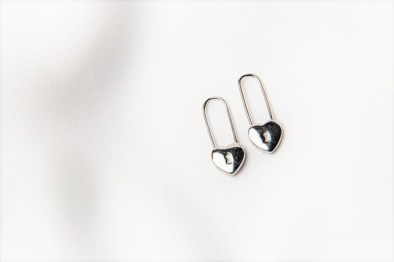 A pair of silver heart lock shaped earrings on a white background