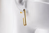 A pair of gold vermeil dangle earrings with a butterfly back design on a white background.