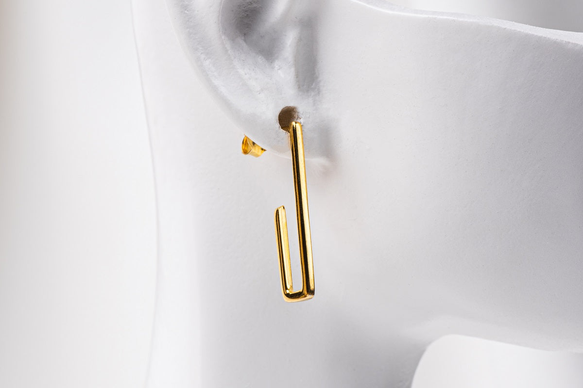 A pair of gold vermeil dangle earrings with a butterfly back design on a white background.