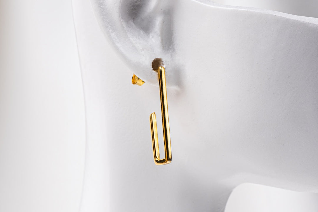 A pair of gold vermeil dangle earrings with a butterfly back design on a white background.