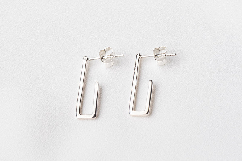A pair of sterling silver dangle earrings with a butterfly back design on a white background.