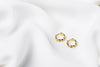 A pair of interlinked gold vermeil hoop earrings on a white background, showcasing a patterned design.