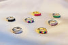 7 hugges earrings on a white background. Some are Silver and some are Gold Vermeil. All feature cubic zirconias of different colors.