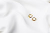 A pair of gold vermeil earrings with rainbow cubic zirconias on a white cloth background